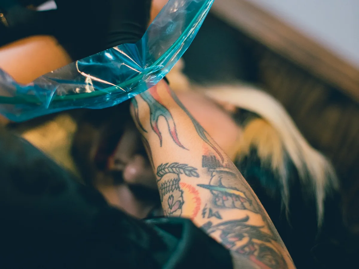 Máquina de tatuar en manos del artista durante una sesión