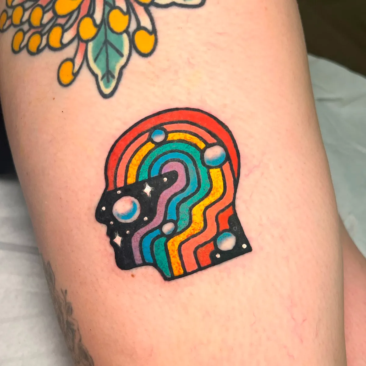 Tatuaje de perfil de cabeza con arcoíris y estrellas